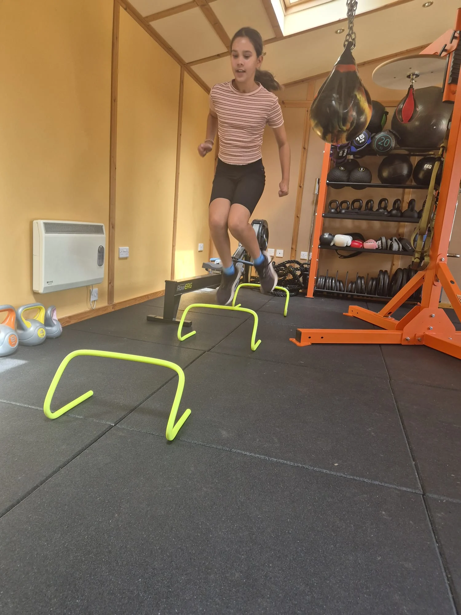 Junior athlete training with agility hurdles in the Osterley PT Studio